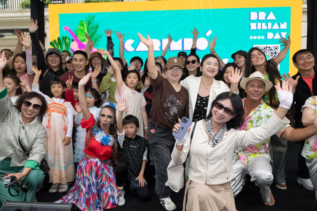 Turistas tiram fotos com artistas brasileiros no palco, em 2 de maio, em Shanghai, no leste da China. (Xinhua/Wang Xiang)