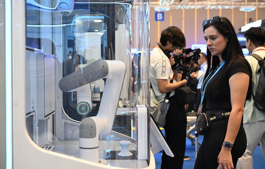 Uma visitante observa um robô sorveteiro na 139ª edição da Feira de Importação e Exportação da China, em Guangzhou, na Província de Guangdong, sul da China, em 15 de abril de 2026. (Xinhua/Deng Hua)