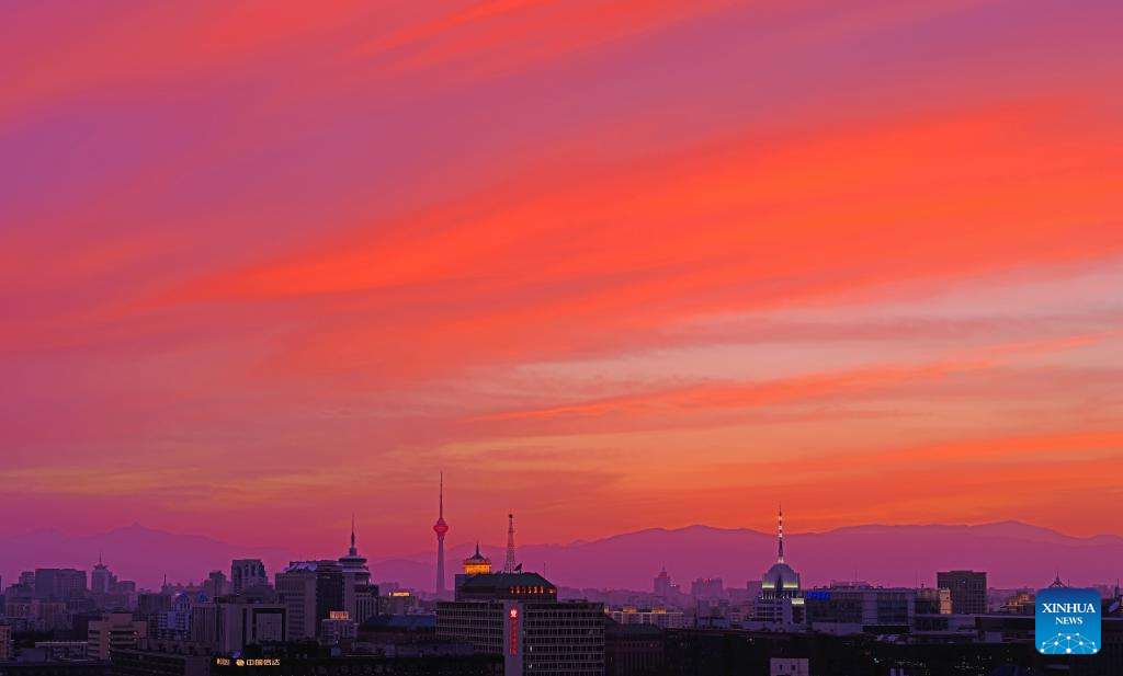 Céu de Beijing ganha tons alaranjados e dourados com nuvens marcantes ao pôr do sol